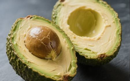 Un avocat coupé en deux, montrant sa chair verte et son noyau.